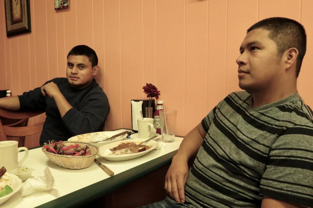 The day Donald Trump delivered his victory speech, New Bedford residents José Ventura, left, and Diego Raymundo talk immigration during their lunch break at a taquería on County Street. Raymundo says immigrants will continue to find a way into the country, even if Trump builds a 40-foot wall. (Simón Rios/WBUR)