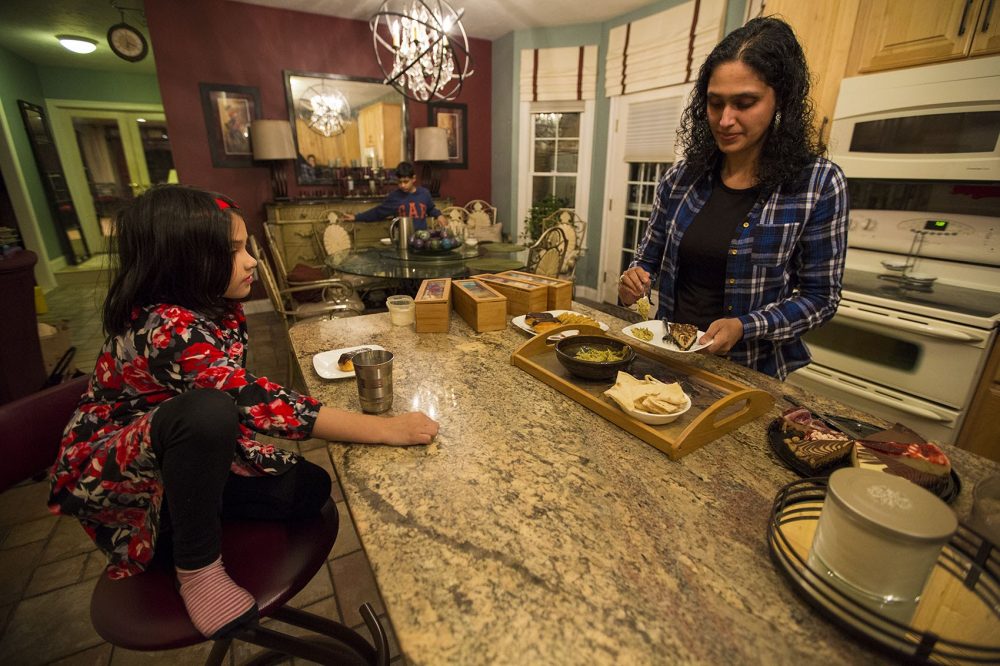 Asima Silva prepares snacks for her family at their home. (Jesse Costa/WBUR)
