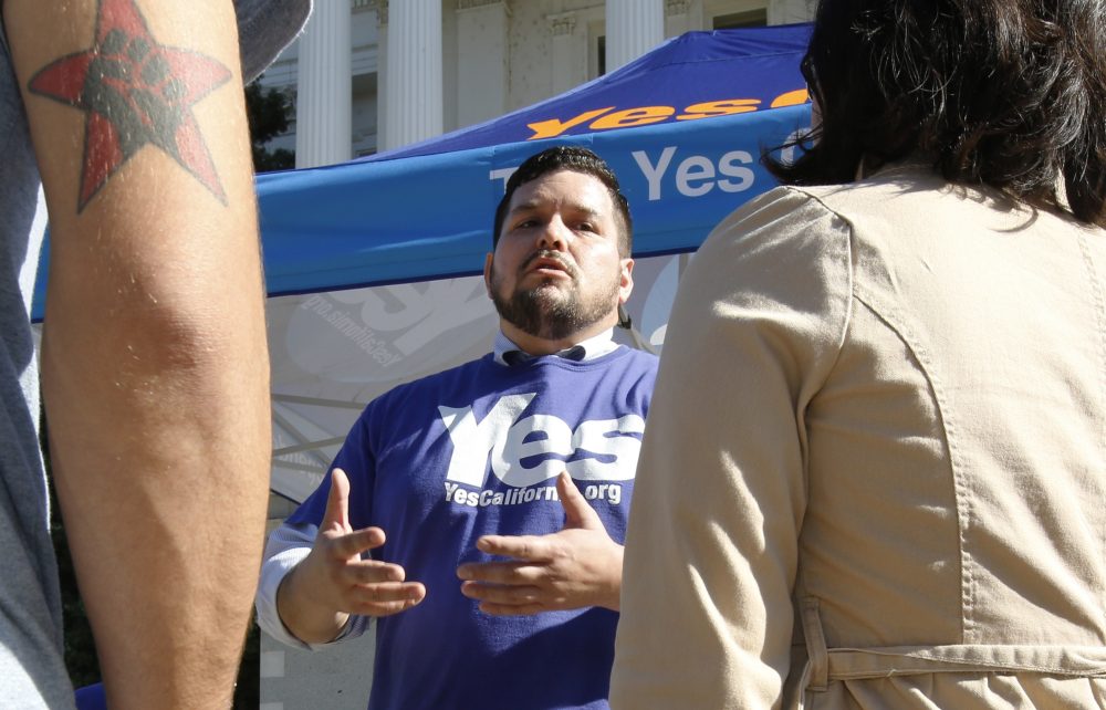 Marcus Ruiz Evans, center, of The Yes California Independence Campaign, talks to passersby about California succeeding from the United States and becoming its own nation, Wednesday, Nov. 9, 2016, in Sacramento, Calif. (Rich Pedroncelli/AP)