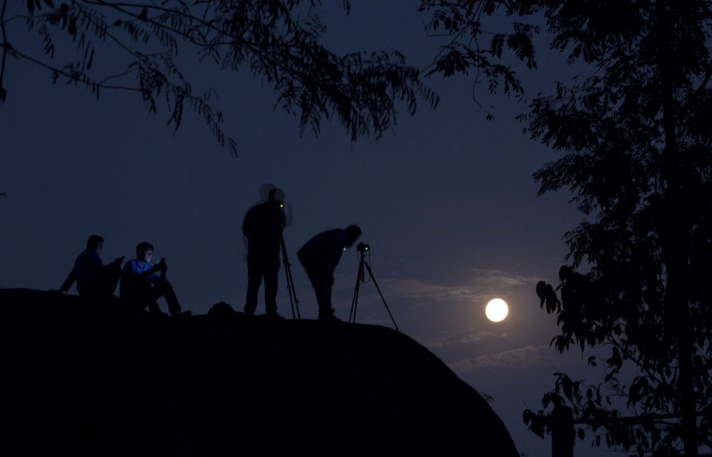 Tourists take photographs of the rising moon in Gauhati, India, Monday, Nov. 14, 2016. (Anupam Nath/AP)