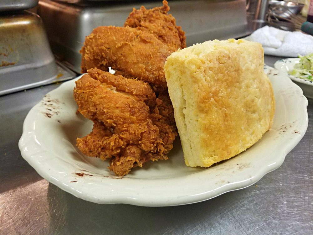 The “Sir Mix a lot” at Whistle Britches in North Dallas, Texas, includes three pieces of golden fried chicken with a side of potato salad and a homemade biscuit. (Stephanie Kuo/KERA)