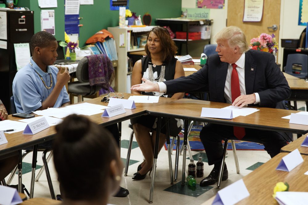 In this Sept. 8, 2016, file photo, then-Republican presidential candidate Donald Trump reaches to shake hands with Egunjobi Songofunmi during a meeting with students and educators before a speech on school choice at Cleveland Arts and Social Sciences Academy in Cleveland. School voucher programs in the nation’s capital and Vice President-elect Mike Pence’s home state of Indiana could serve as a blueprint for a Trump administration education plan. (Evan Vucci/AP, File)