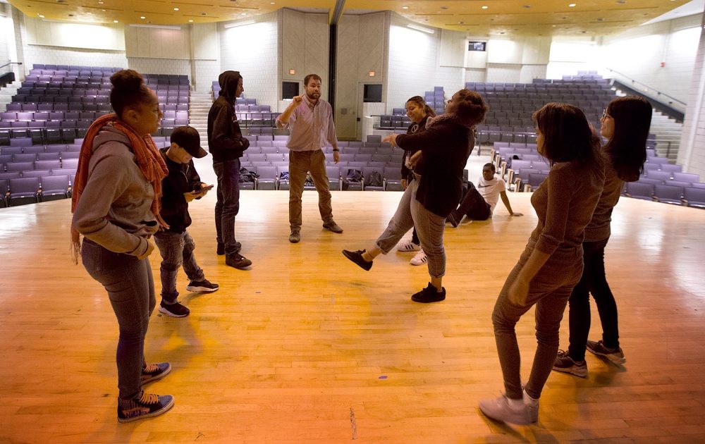 Charlestown High School teacher Alex Johnson (center) leads a theater exercise. Until this year, the school hadn't had a dedicated drama program for two decades. (Jesse Costa/WBUR)