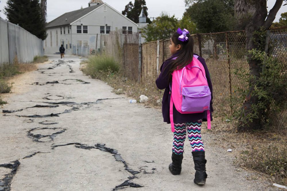 Celia Fragoso, 7, walks through the Oakland neighborhood of Sobrante Park on her way to Madison Park Academy on Aug. 26, 2016. (Brittany Hosea-Small/KQED)