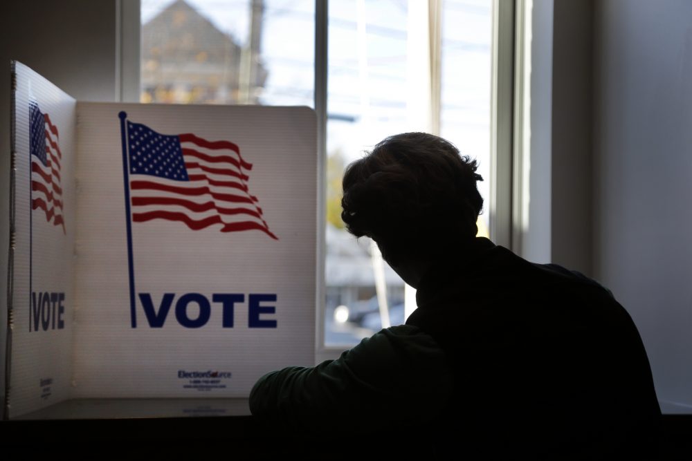 A voter fills out an early ballot envelope at North Andover Town Hall on Monday. (Elise Amendola/AP)