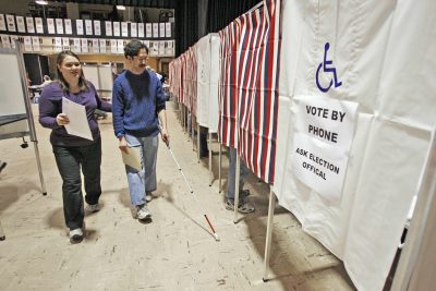 The voting rights of America's disabled citizens must be dealt with now, writes Ross Doerr. Pictured: A blind man is helped to a voting booth by an  election worker in Montpelier, Vt. (Toby Talbot/AP)