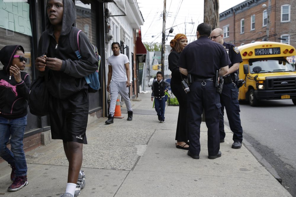 Police officers talk with a community activist in New York on May 24, following deaths of black men in encounters with police in Minnesota, Louisiana and across the country, and the sniper killing of five Dallas officers. (Seth Wenig/AP)