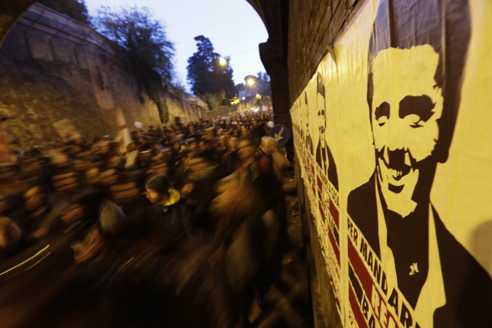Protesters march past a poster depicting Italian Premier Matteo Renzi during a demonstration ahead of a referendum over a constitutional reform, in Rome, Sunday, Nov. 27, 2016. (Andrew Medichini/AP)