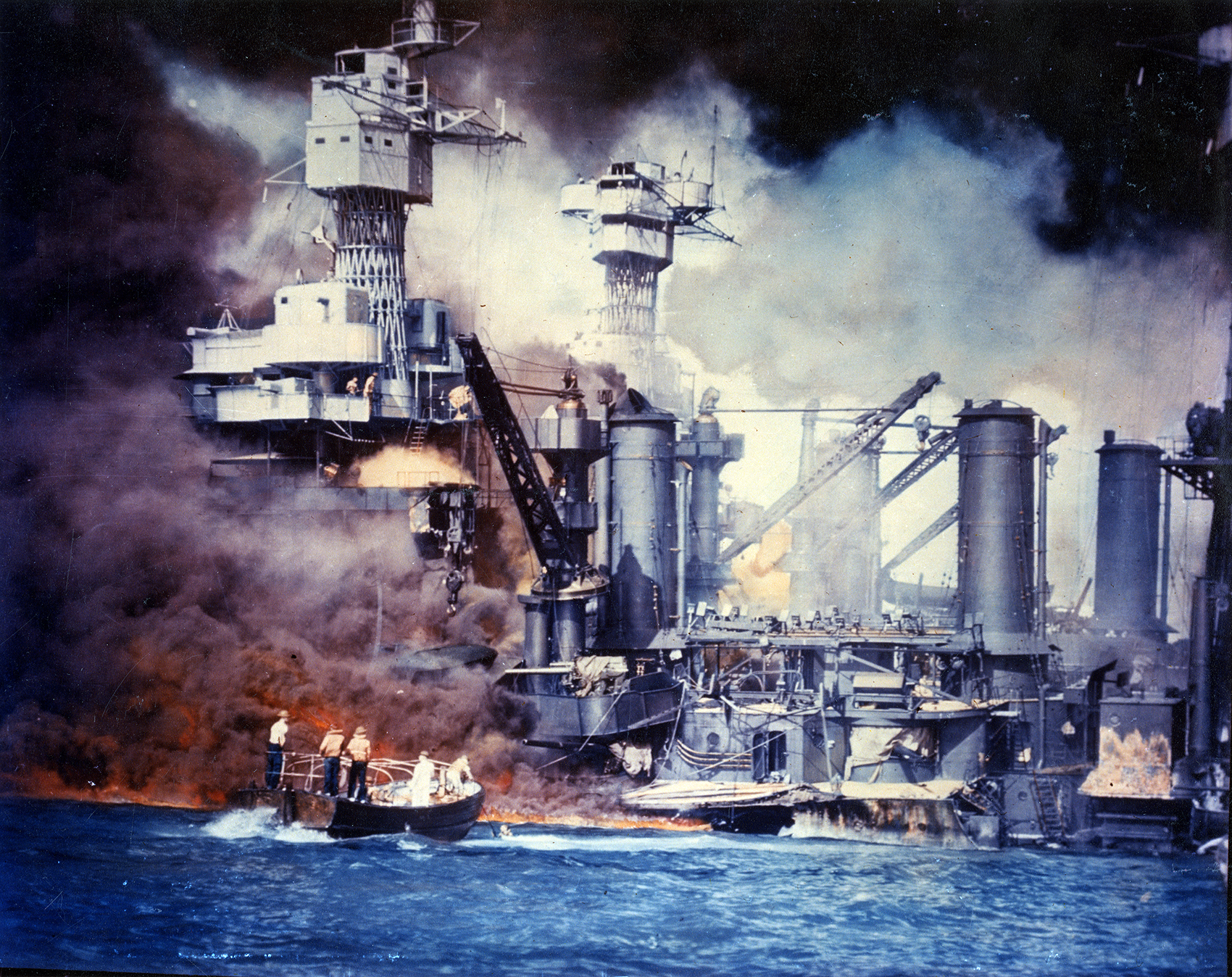 Sailors in a motor launch rescue a survivor from the water alongside the sunken USS West Virginia (BB-48) during or shortly after the Japanese air raid on Pearl Harbor. USS Tennessee (BB-43) is inboard of the sunken battleship. (Courtesy Army Signal Corps Collection/U.S. National Archives)