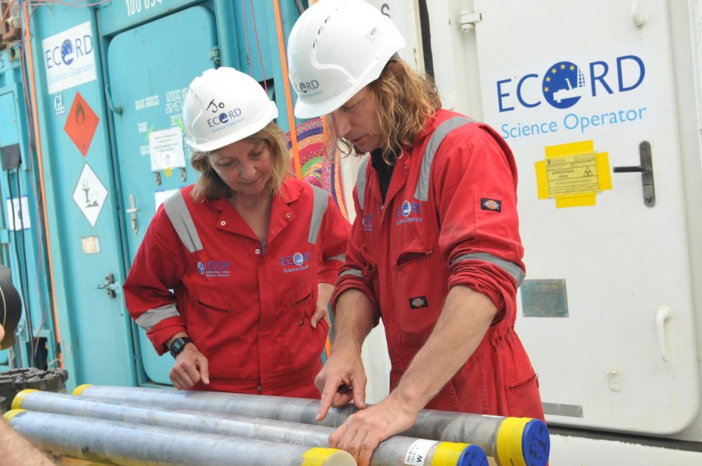 Imperial College London researcher Joanna Morgan (left) and UT researcher Sean Gulick examine a sample from the site of the Chicxulub asteroid site. (UT Jackson School of Geosciences)