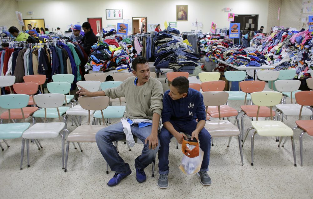 Roger Mesa, right, a 15-year-old from Honduras who is headed to Miami with his father, Luis Carlos, a construction worker, left, sit at the Sacred Heart Community Center in the Rio Grande Valley border city of McAllen, Texas, Sunday, Nov. 13, 2016, after they were released after processing by U.S. Customs and Border Patrol. (Eric Gay/AP)