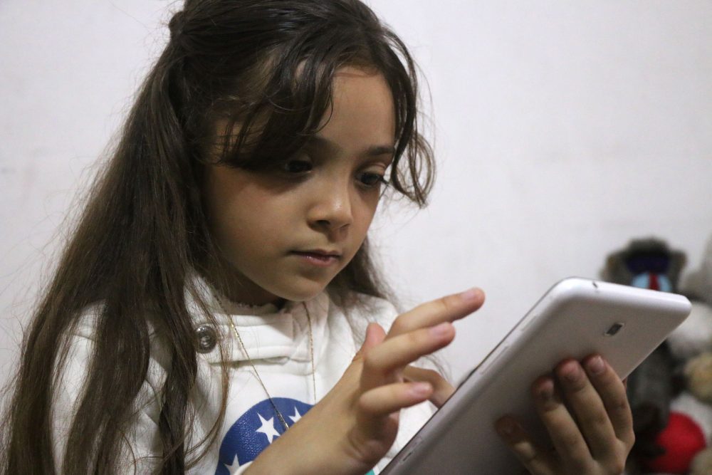Syrian Bana al-Abed, who with the help of her mother had been posting heartrending tweets in English on life in the besieged eastern districts of Syria's Aleppo, uses a smart-phone to check her Twitter account in her home in east Aleppo, on Oct. 12, 2016. (Thaer Mohammed/AFP/Getty Images)