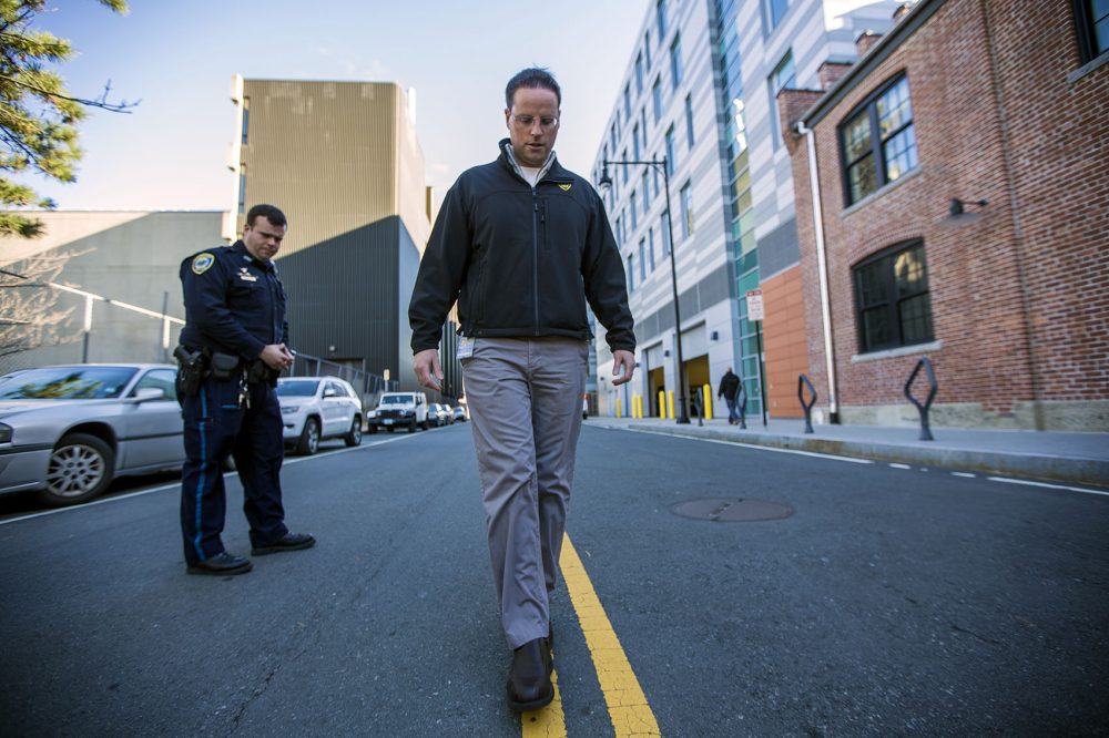 Cambridge Police officer Jason Callinan and Jeremy Warnick, a spokesman for the department, demonstrate the walk and turn line test down the center of Rogers Street. (Jesse Costa/WBUR)