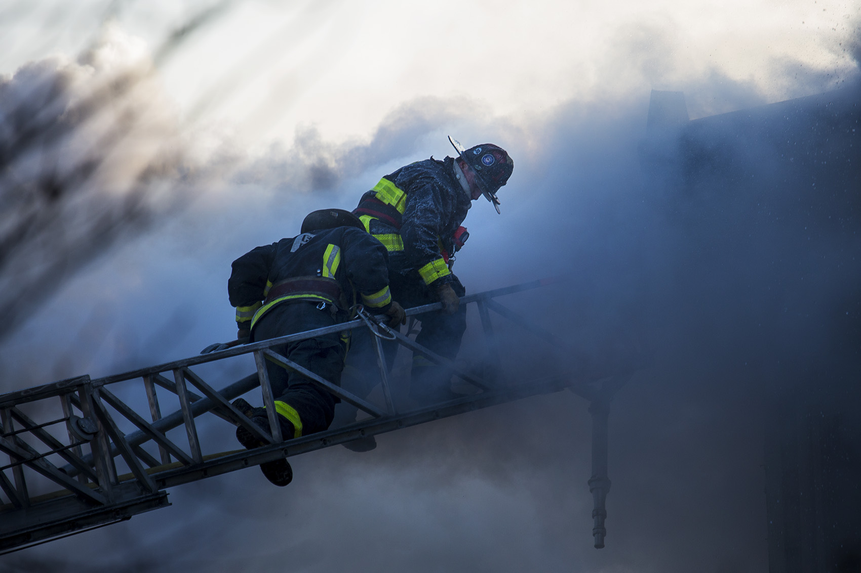 Boston firefighters battle the smoke of a smoldering fire on Bunker Hill Street in Charlestown. (Jesse Costa/WBUR)