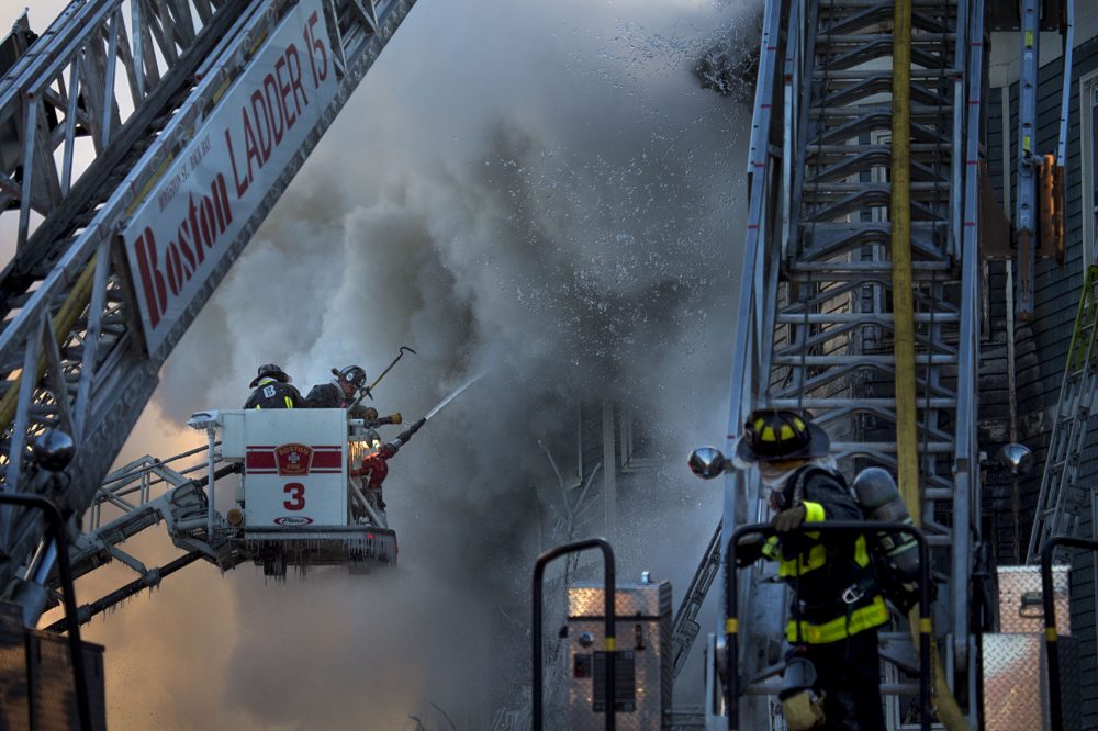 Boston firefighters battle a smoldering fire on Bunker Hill Street in Charlestown. (Jesse Costa/WBUR)
