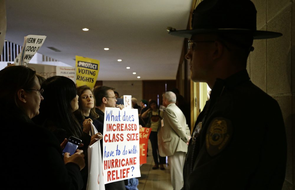 Demonstrators gather outside of a press conference room during a special session at the North Carolina Legislature in Raleigh, N.C., Thursday, Dec. 15, 2016. (Gerry Broome/AP)
