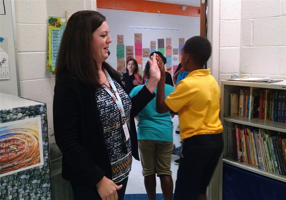 Jennifer Burnell high-fives students as they leave her classroom at Fall-Hamilton Elementary School. (Chas Sisk/WPLN)