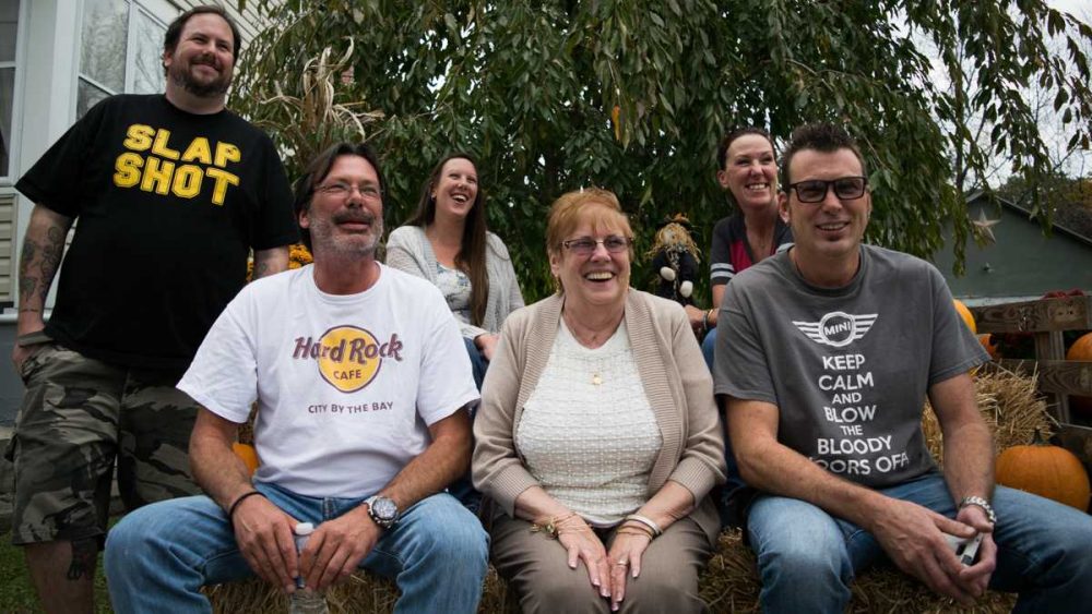 Front row: Scott Winter, left, sits next to his biological mom, Nancy Oakes Dewitt, and his older brother, Keith Murphy. In the second row, Charles Murphy, Jeannette Murphy and Lynnae DePaolo. (Paige Pfleger/WHYY)