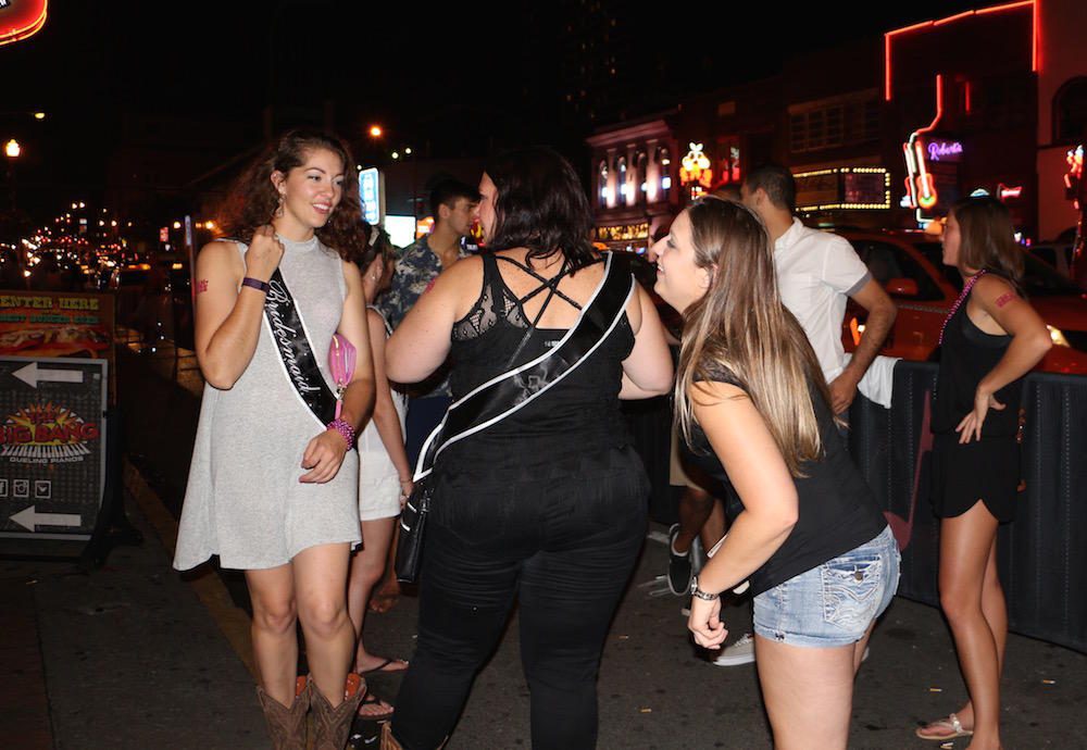 A bachelorette party hangs out outside a bar on Broadway in Nashville. (Caroline Miller/For WPLN)
