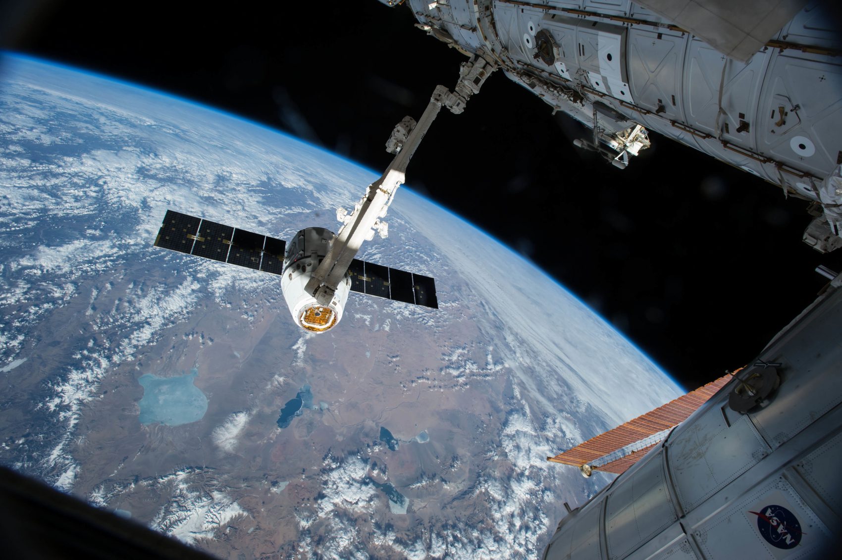 In this April 17, 2015 photo, the Canadarm 2 reaches out to capture the SpaceX Dragon cargo spacecraft for docking to the International Space Station. (NASA/AP)