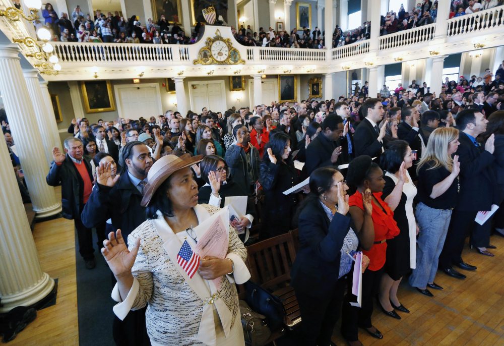 Gina Dominique, lower left, who came from Haiti, takes the oath of U.S. citizenship during a naturalization ceremony in Boston, Thursday, April 2, 2015. Nearly 400 people from dozens of countries ranging from Albania to Zimbabwe took part in the ceremony. (Michael Dwyer/AP)