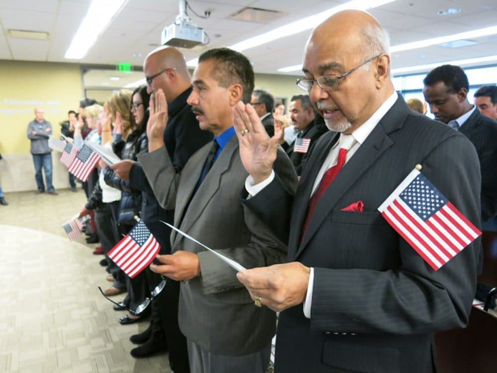 Julio Martinez and Ronald Shaw each take the Oath of Allegiance at a naturalization ceremony in Centennial, Colorado. (Sam Brasch/CPR News)