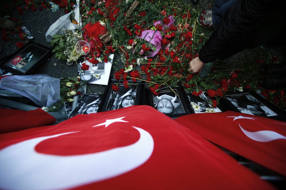 A man leaves carnations at the scene as people protest against the attack and in memorial to the victims of the nightclub New Year's Day attack, in Istanbul, Tuesday, Jan. 3, 2017. (Emrah Gurel/AP)