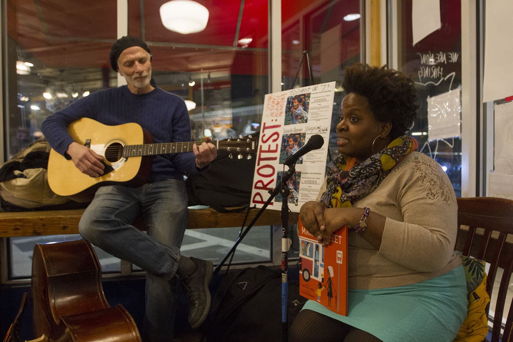 Tanya Nixon-Silberg, storyteller and co-founder of Wee The People, reads stories with Jeffrey Benson providing background music, during a ResistARTS performance in early January. (Joe Difazio for WBUR.)