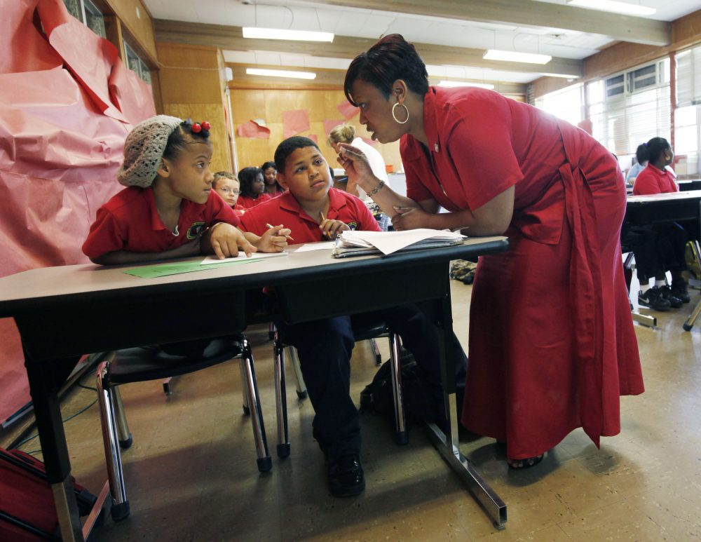 Trenise Duvernay talks to Miracle Lee, left, and Danny Dinet, center, as she teaches fourth grade math class at the Alice M. Harte Charter School in New Orleans in April 2010. (Gerald Herbert/AP)