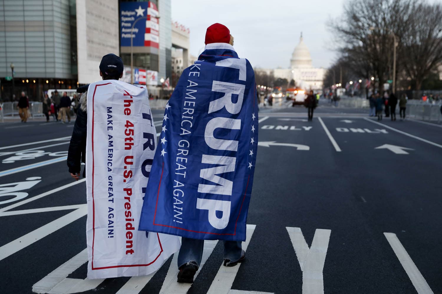 Supporters of President-elect Donald Trump walk along Pennsylvania Avenue Thursday after it was closed down to thru-traffic as security tightens ahead of the presidential inauguration. (John Minchillo/AP)