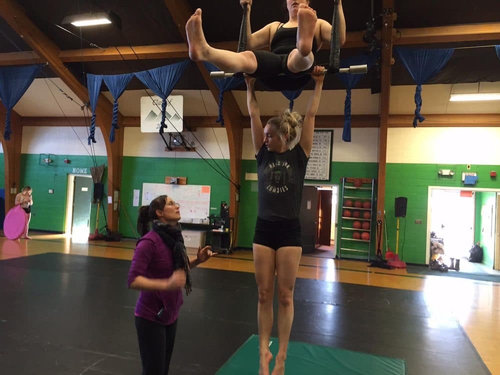 As Ringling Bros. announces it will close, New England Center for Circus Arts in Brattleboro is keeping the art of circus performing alive. The group's co-founder Elsie Smith (left) works with Cherie Jacque and Miranda Kent on the trapeze. (Howard Weiss-Tisman/VPR)
