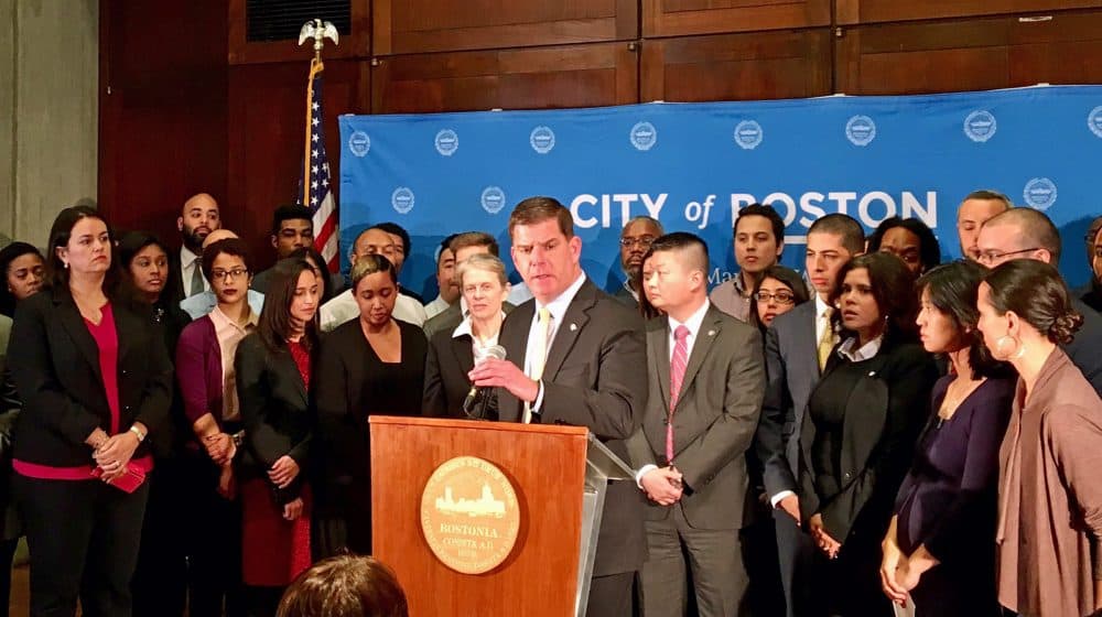 Surrounded by members of his administration and state lawmakers, Mayor Marty Walsh announced Boston will maintain its status as a &quot;sanctuary city.&quot; (Shannon Dooling/WBUR)