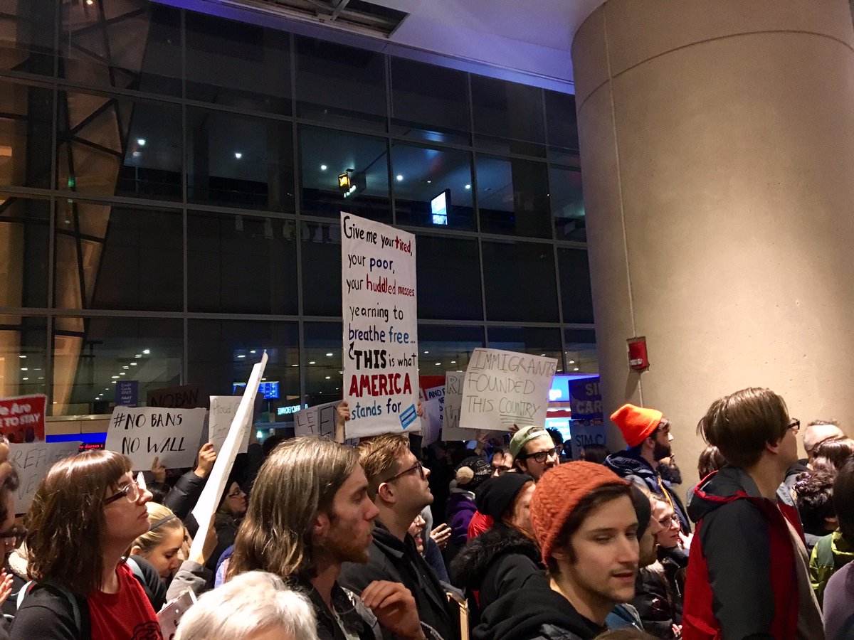 Protesters gathered at Logan Airport's Terminal E Saturday night and early Sunday morning in opposition to President Trump's executive order on immigration. (Shannon Dooling/WBUR)