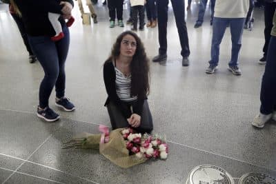 The crisis over President Trump's immigration ban, writes John Tirman, has emerged from its unconstitutionality as well as from the way the government has flaunted court orders blocking parts of the ban. Pictured: Reem Alrubaye, of Fremont, Calif., places flowers on the floor as she waits for her mother Mason Jadoaa to return from a visit to Baghdad, Iraq, at San Francisco International Airport, Monday, Jan. 30, 2017. (Marcio Jose Sanchez/AP)