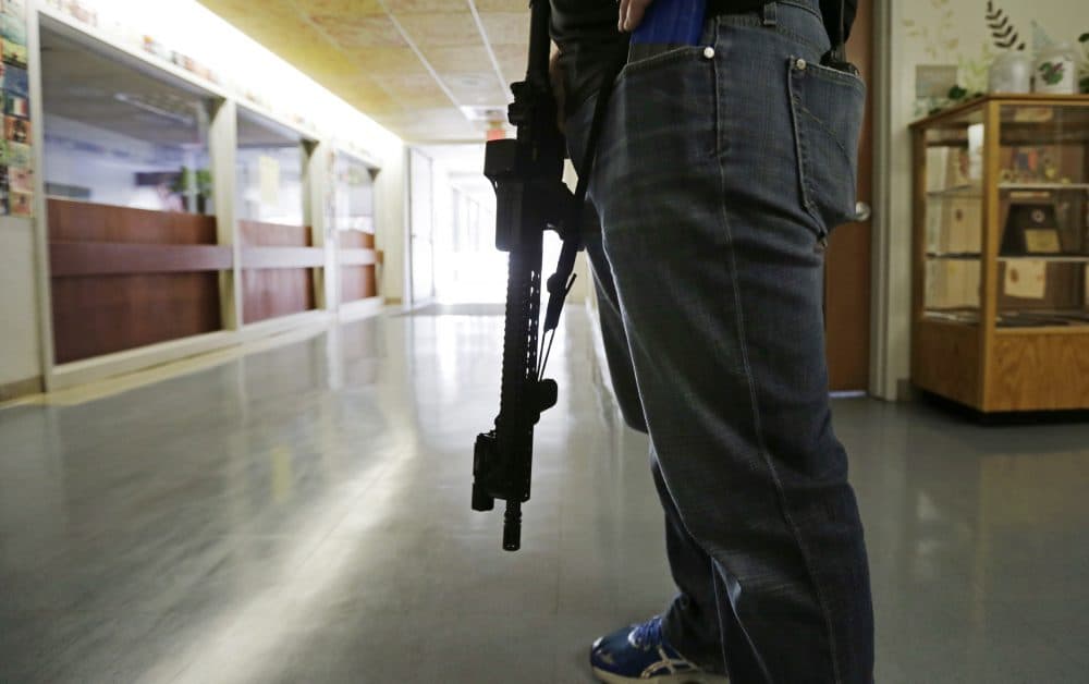 Lt. Greg Gallant, of the Methuen Police Department, portrays an active shooter as he roams the halls of a school with an assault rifle, loaded with dummy rounds, during a 2014 demonstration. (Charles Krupa/AP)
