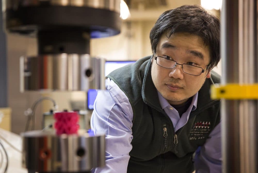 MIT research scientist Zhao Qin sets up an experiment in the lab. He was on the team that discovered a gyroid structure that makes materials more resilient. (Robin Lubbock/WBUR)