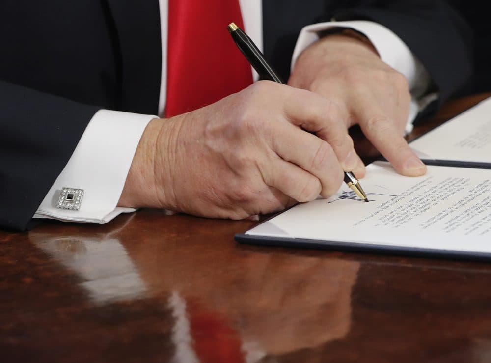 President Donald Trump signs an executive order in the Oval Office of the White House in Washington. (Pablo Martinez Monsivais/AP)