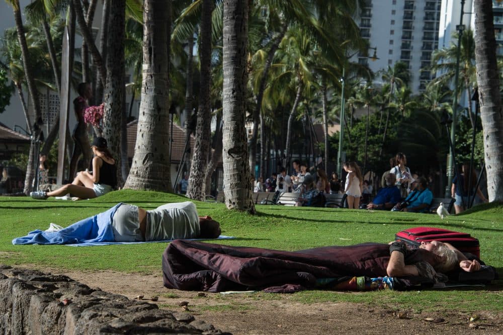 Homeless people sleep in a park off the beach in the Waikiki neighborhood of Honolulu, Hawaii, on Dec. 17, 2016. (Nicholas Kamm/AFP/Getty Images)