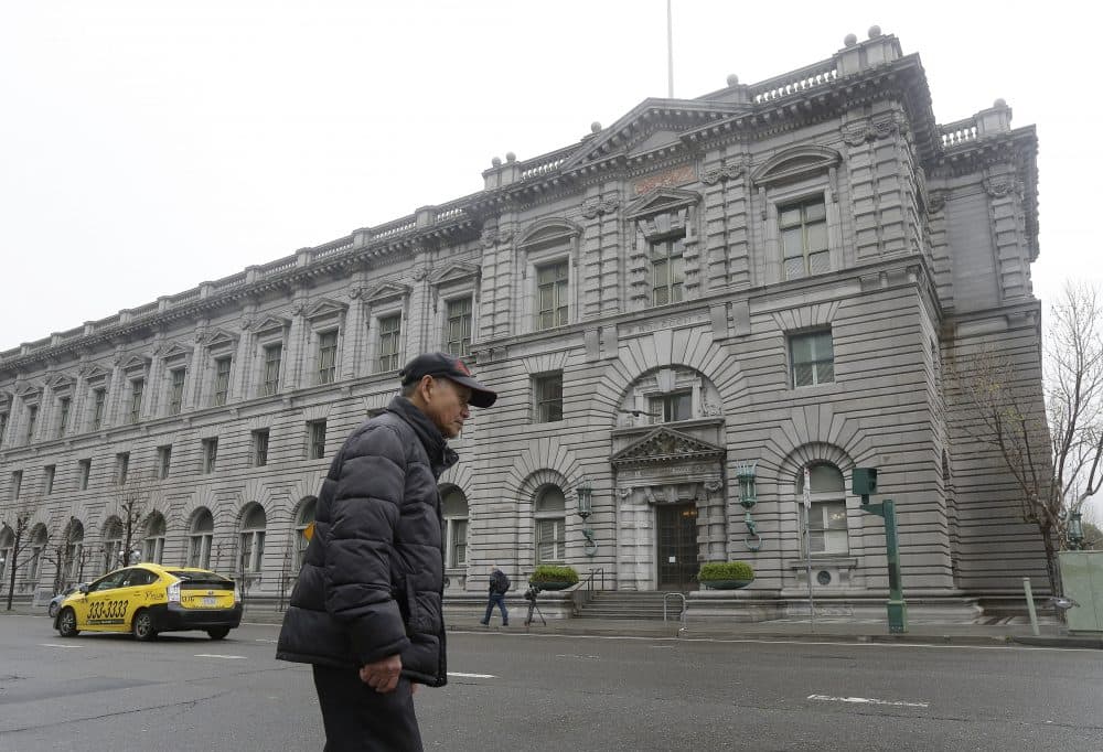 A man walks outside of the 9th U.S. Circuit Court of Appeals in San Francisco, Tuesday, Feb. 7, 2017. President Donald Trump's travel ban faced its biggest legal test yet Tuesday as a panel of federal judges prepared to hear arguments from the administration and its opponents about two fundamentally divergent views of the executive branch and the court system. (Jeff Chiu/AP)