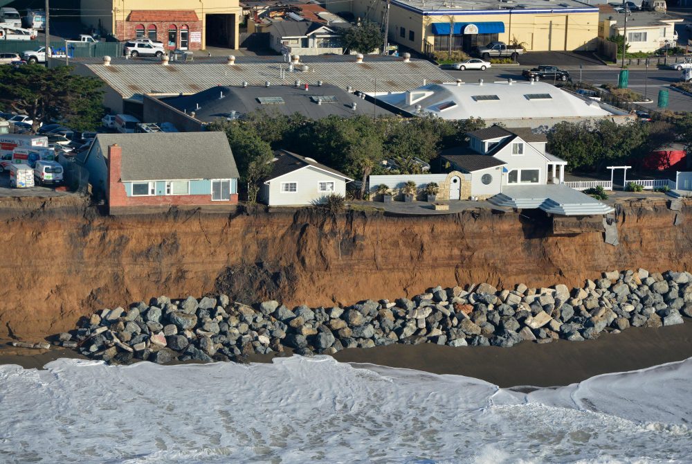 Houses hang over a cliff in Pacifica, Calif., in January 2016. Storms and powerful waves caused by El Nino have been intensifying erosion. (Josh Edelson/Getty Images)