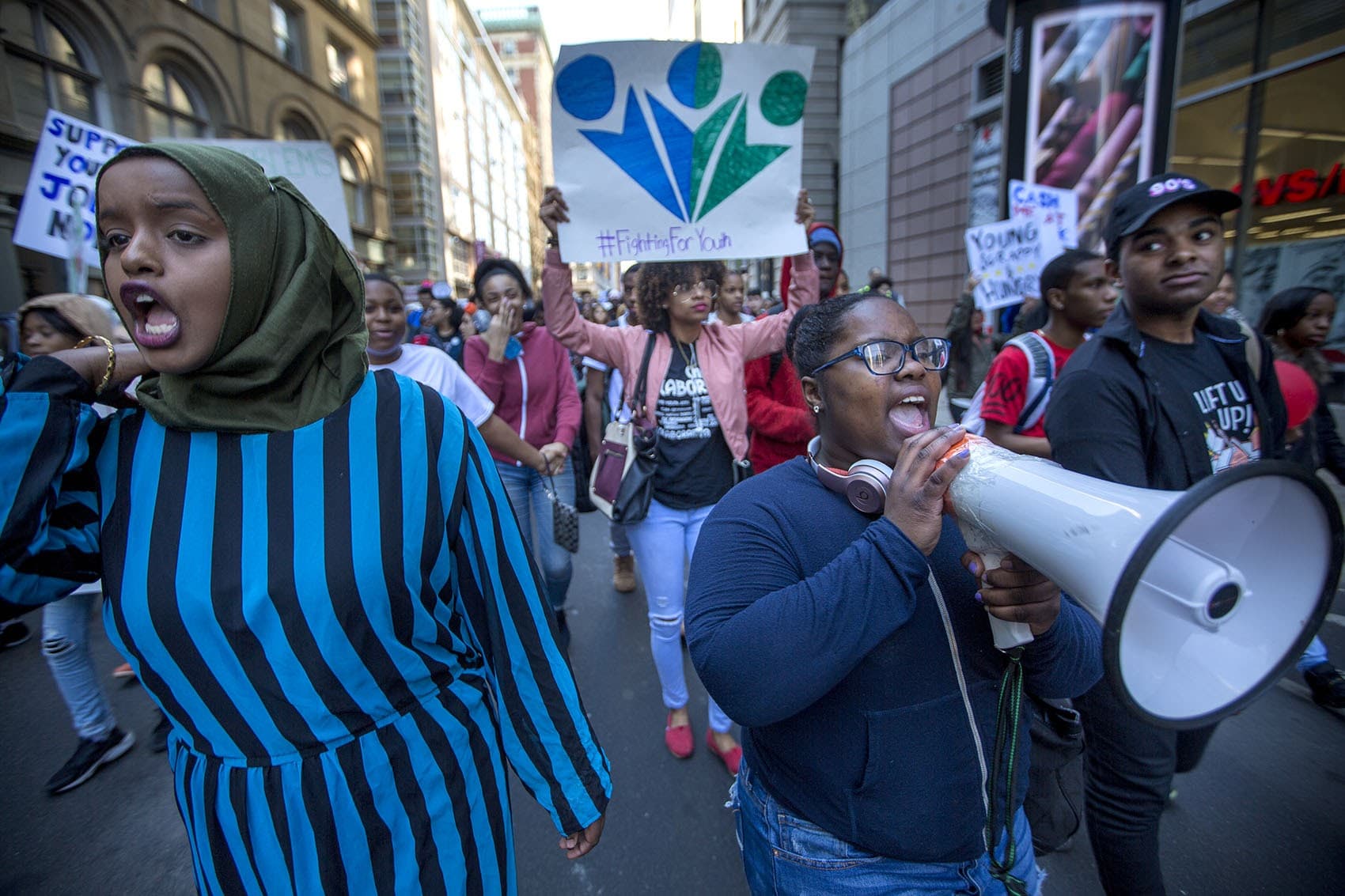 Youth activists march through Downtown Crossing Thursday afternoon. They are calling on state and city leaders to fund more youth jobs and reform the juvenile justice system. (Jesse Costa/WBUR)