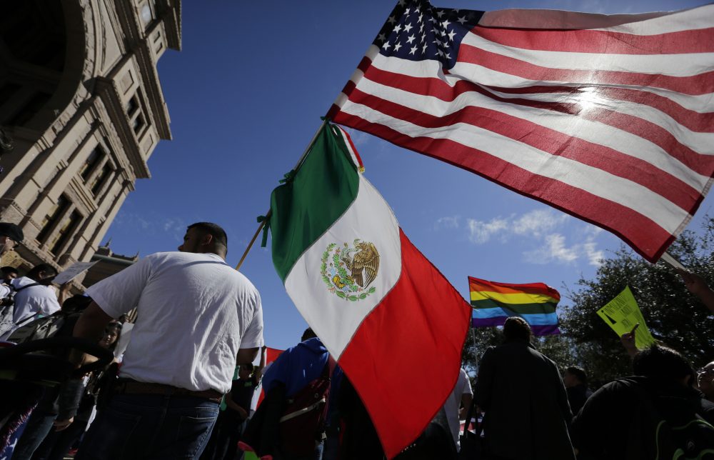 A man holds the U.S. and Mexico flags during a march and rally during an immigration protest, Thursday, Feb. 16, 2017, in Austin, Texas. (Eric Gay/AP)