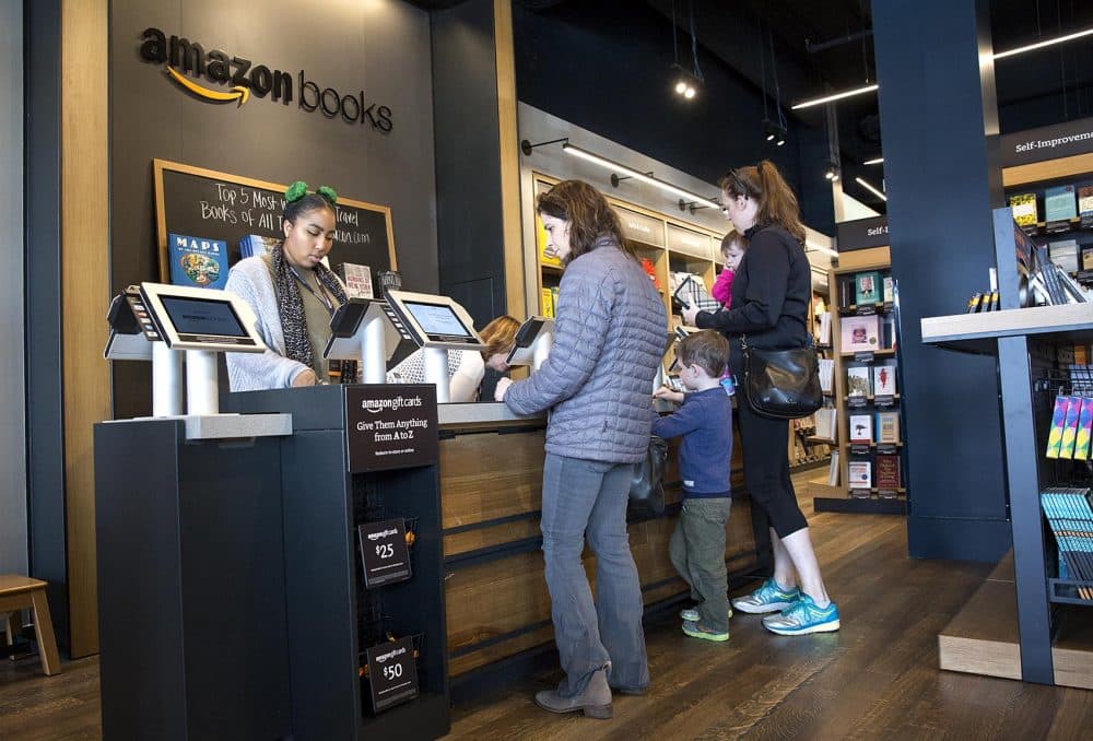 Jessica Booker, left, completes a book sale at the Amazon store in Dedham. (Robin Lubbock/WBUR)