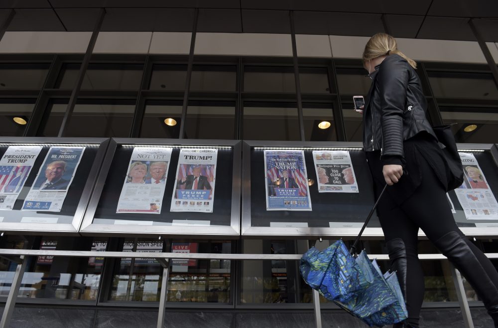 A woman views the front pages of newspapers on display outside the Newseum in Washington on Nov., 9, 2016, the day after the presidential election. (Susan Walsh/AP)
