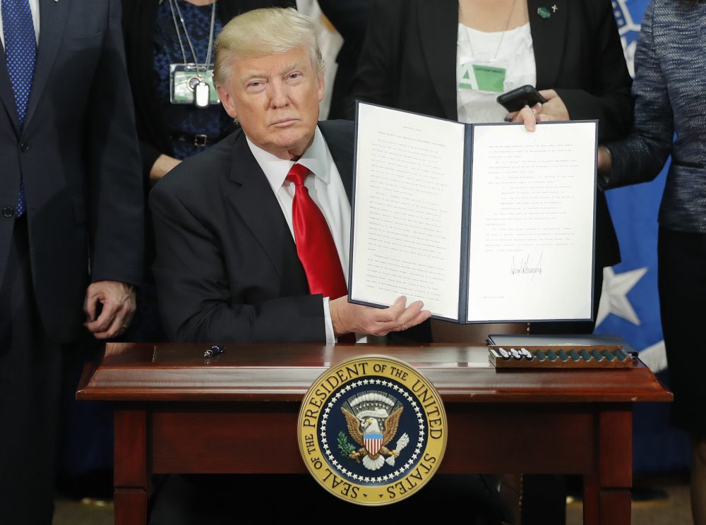 President Trump holds up an executive order for border security and immigration enforcement improvements during a visit to the Homeland Security Department headquarters in Washington on Jan. 25. (Pablo Martinez Monsivais/AP)