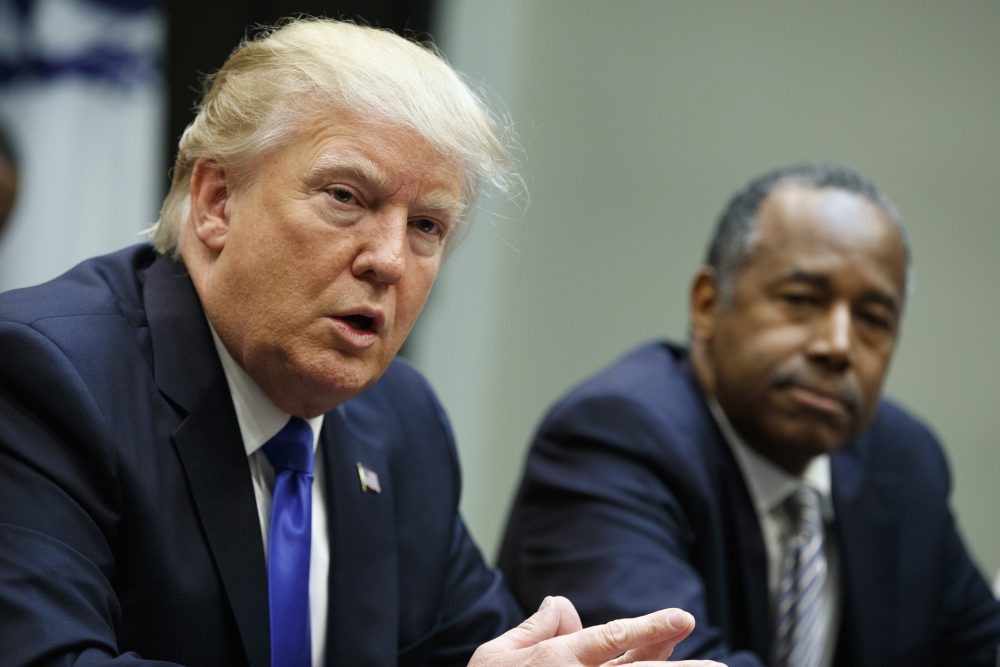 The rising murder rate in Chicago is a serious problem, writes Kevin C. Peterson. But Trump has turned the violence into an unfair stereotype of African Americans. Pictured: Housing and Urban Development Secretary-designate Ben Carson listens at right as President Donald Trump speaks during a meeting on African American History Month in the Roosevelt Room of the White House in Washington, Wednesday, Feb. 1, 2017. (Evan Vucci/AP)