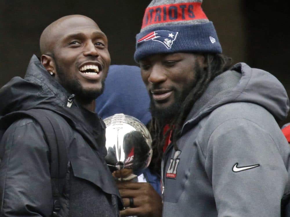 Patriots safety Devin McCourty, left, and running back LeGarrette Blount, seen here during the team's parade through Boston Tuesday, have both announced they're skipping the traditional White House visit for Super Bowl champions. (Elise Amendola/AP)