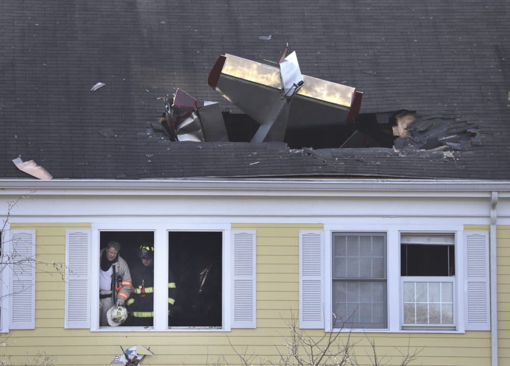 Firefighters investigate the scene after a small plane crashed into the roof of a condominium building in Methuen, Tuesday. (Elise Amendola/AP)