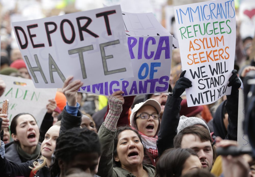By targeting immigrants, the administration puts our global universities, hospitals, scientific research centers and start-ups at risk. Pictured: Demonstrators display placards in Boston, Sunday, Jan. 29, 2017, during a rally against President Donald Trump's order that restricted travel to the U.S. (Steven Senne/AP)