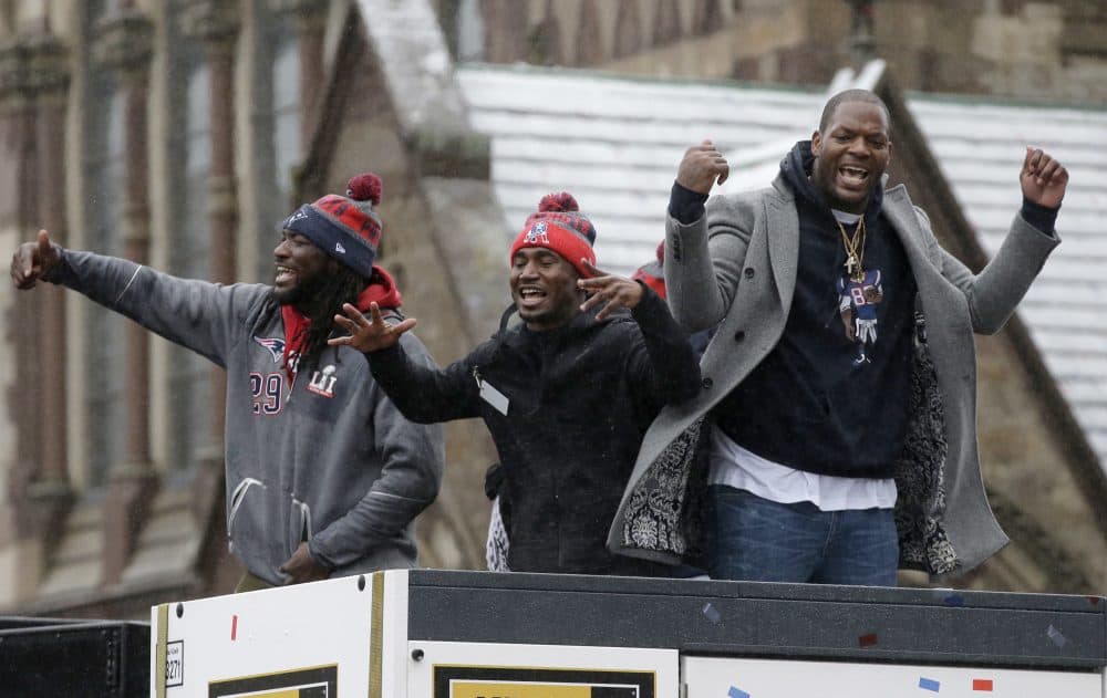 New England Patriots LeGarrette Blount, left, Dion Lewis, center, and Martellus Bennett wave during the parade in Boston to celebrate their Super Bowl win. (Steven Senne/AP)
